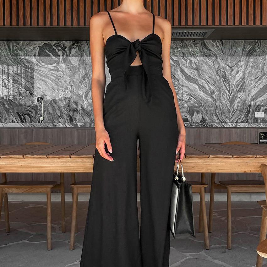 Black sling wide-leg jumpsuit with bow at bust and flowing wide pants