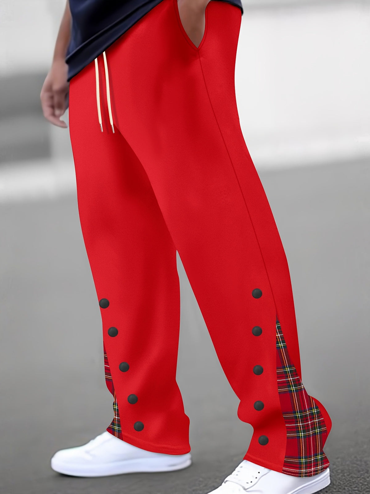 Red color-block trousers with black dot accents and red plaid side panel