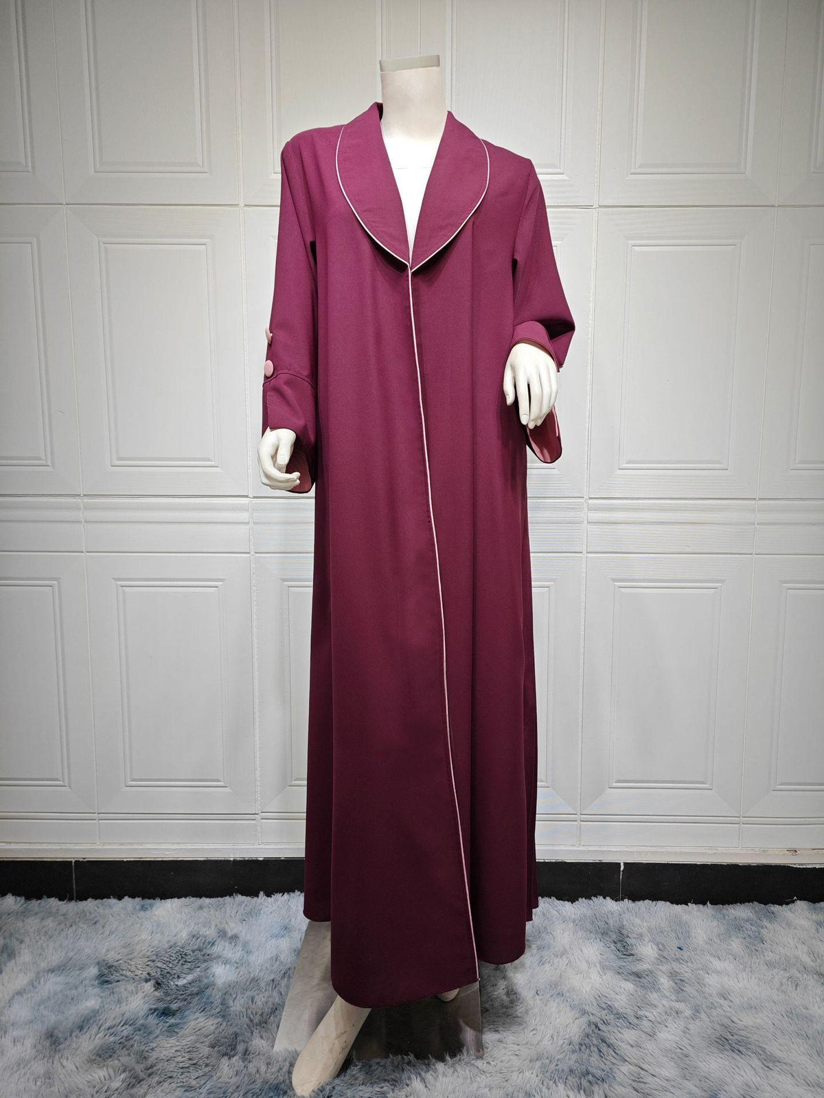 Long cardigan dress in purplish red with open lapel neckline and contrasting trim.