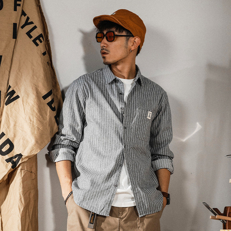 Gray vertical-striped button-up shirt, long sleeves, chest logo patch