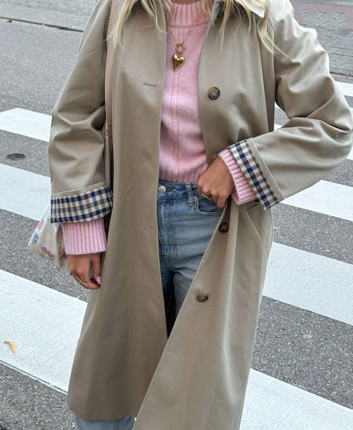 Women’s khaki trench coat with button closure and plaid-lined cuffs