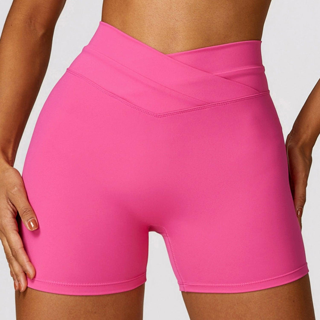 High-waisted yoga shorts in bright magenta pink with V-shaped cross front waist