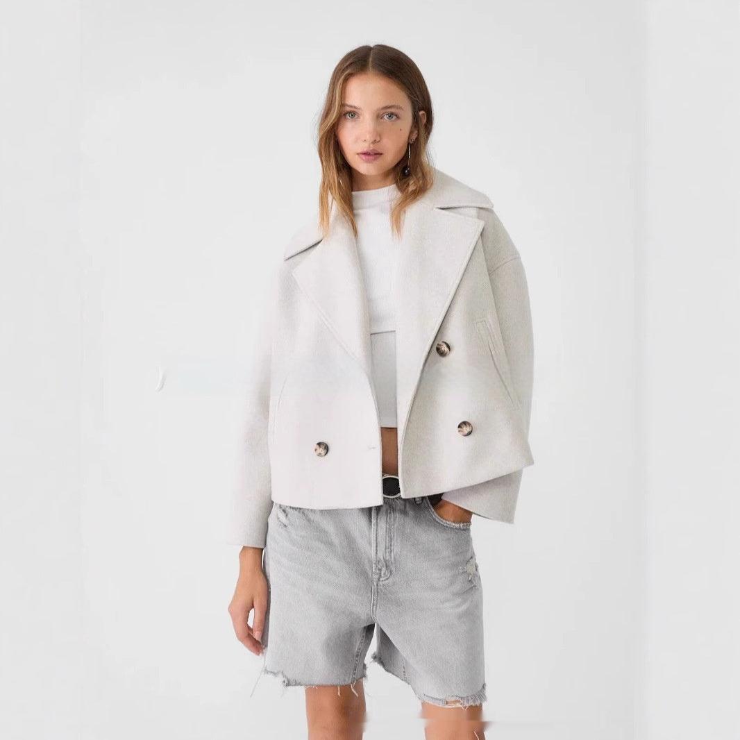 Beige long-sleeve coat with notch lapels and double-breasted button closure.