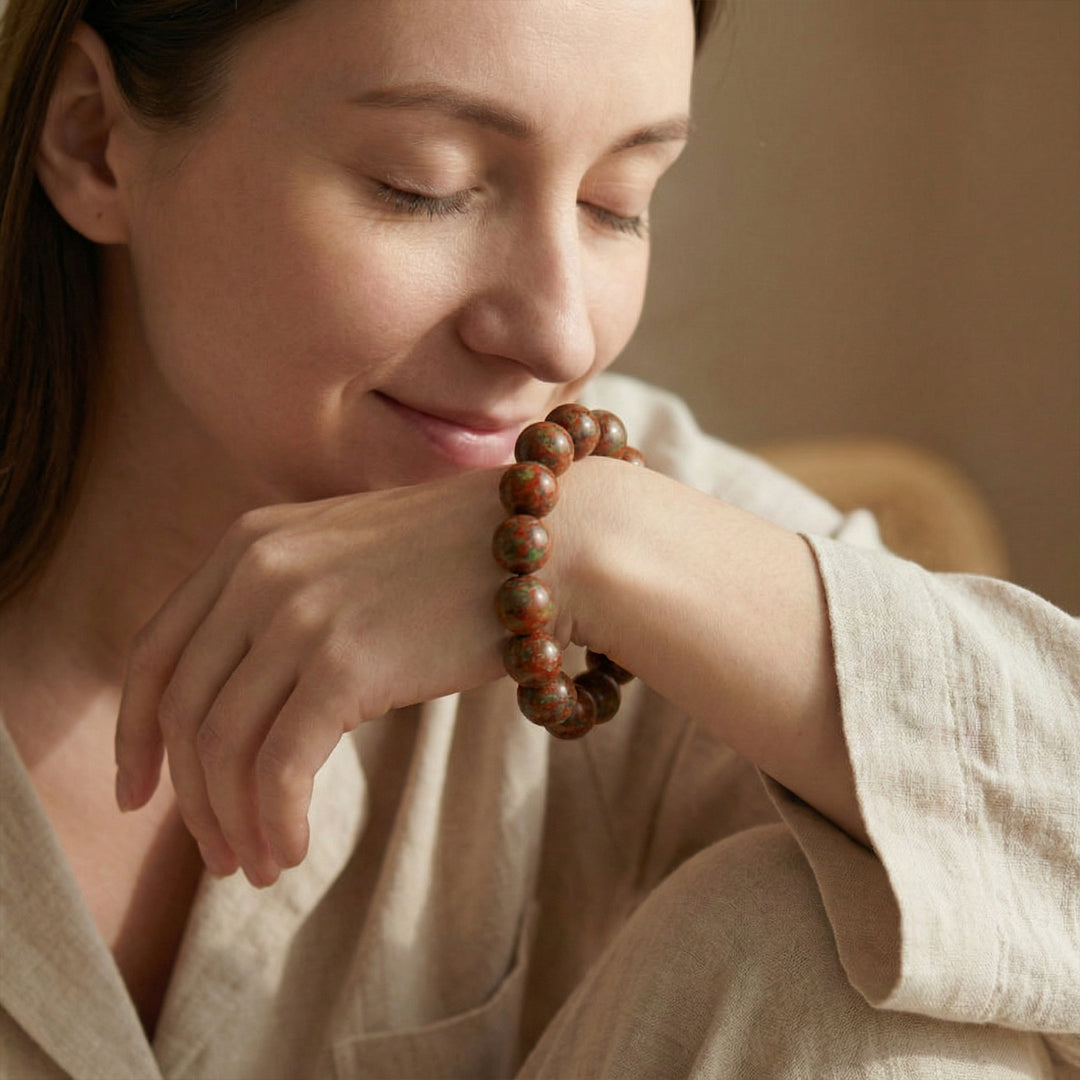 Bead bracelet with round brown and gold-toned beads, worn on a wrist.
