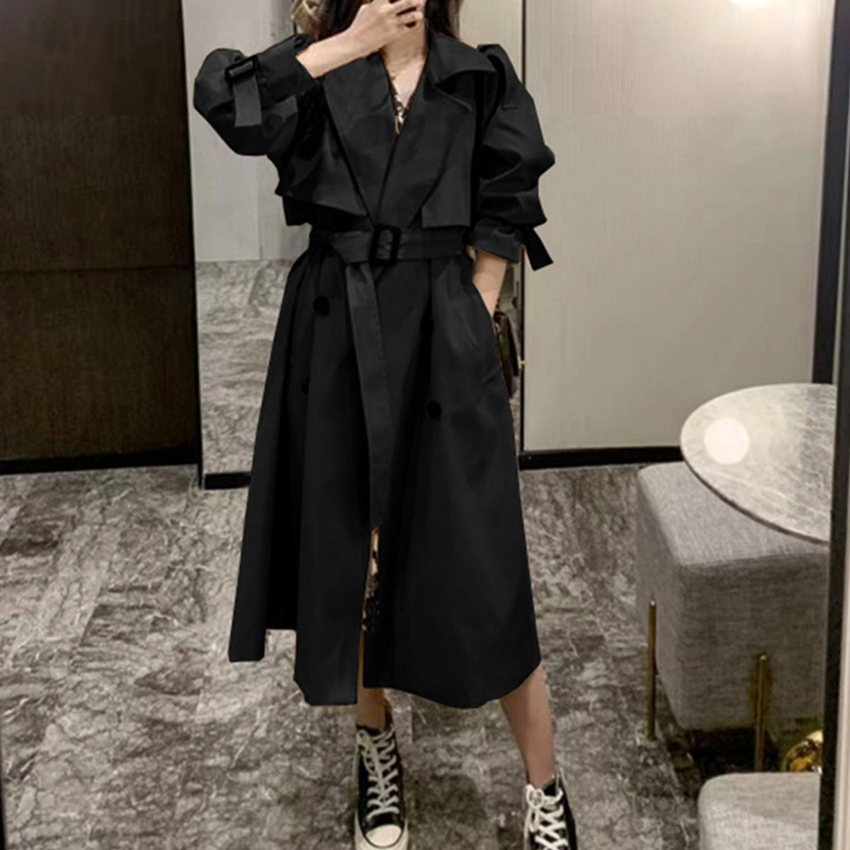 Women’s black trench coat with belt tie, notched lapels, and double-breasted buttons