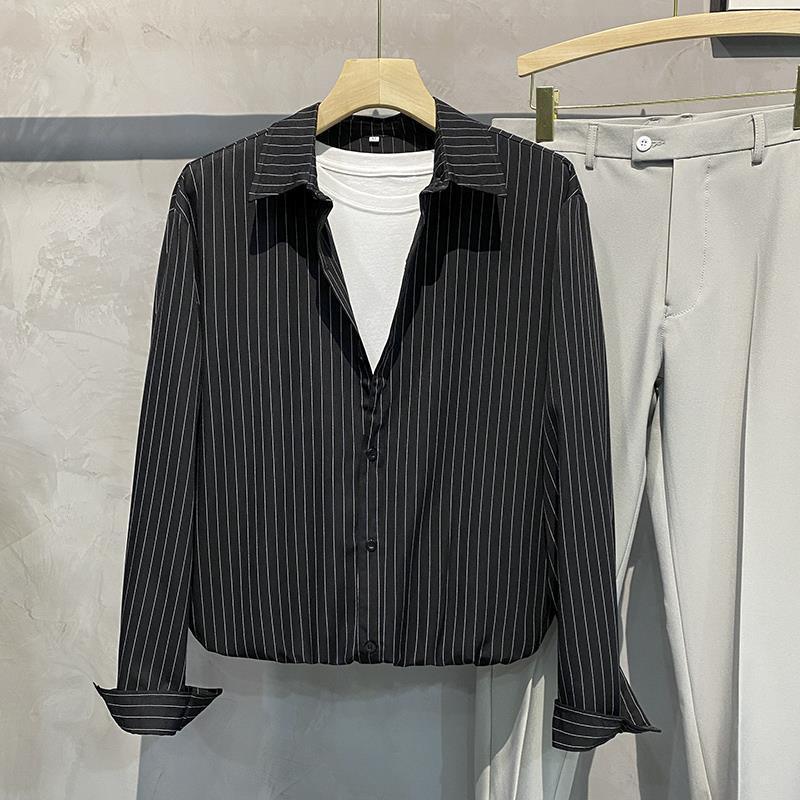 Black striped button-up overshirt with pointed collar and long sleeves on hanger