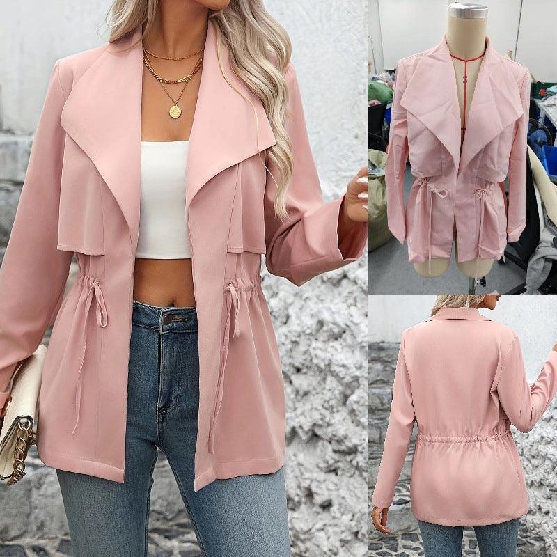 Pink trench coat with wide lapel, drawstring hem, and tie sleeves over dark jeans