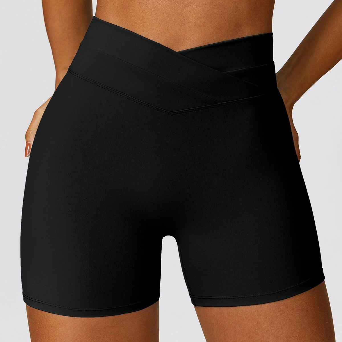 High-waisted yoga shorts in solid black with V-shaped cross front waist