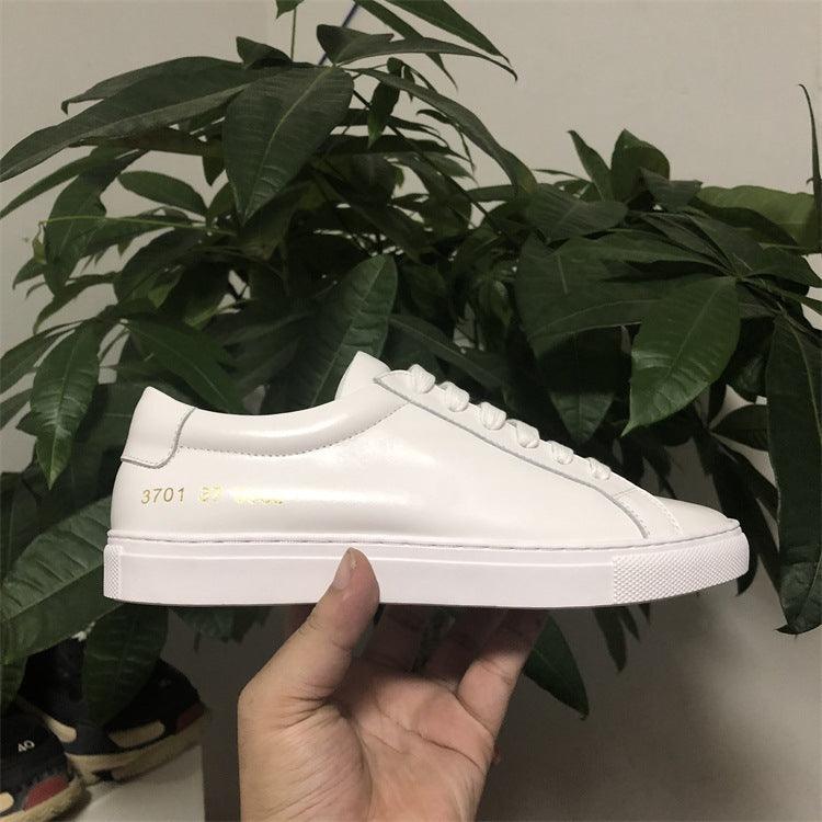 White genuine leather low-top sneakers with lace-up front and rubber cupsole.