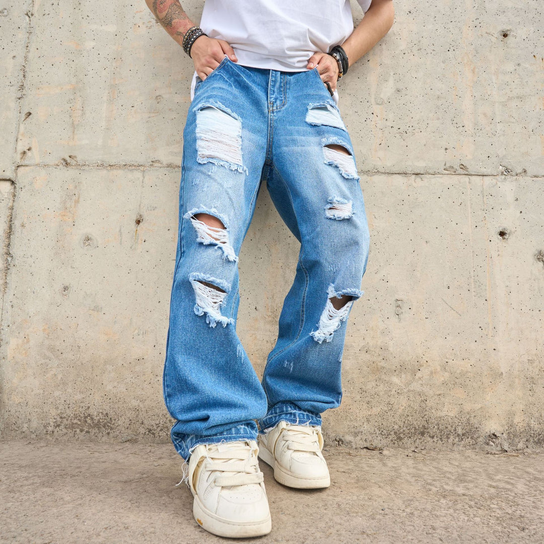 Men's loose-fit blue jeans with ripped knees and light-wash distressed patches