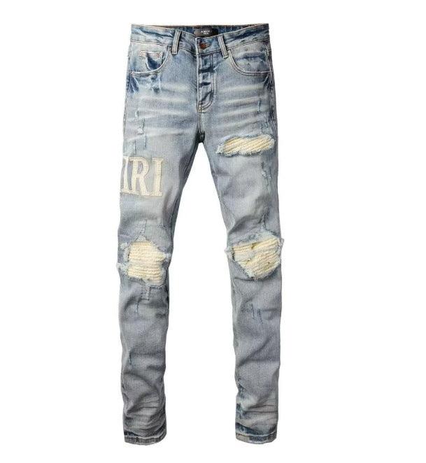 Light blue slim jeans with “IRI” print and small ripped, patchy knee areas