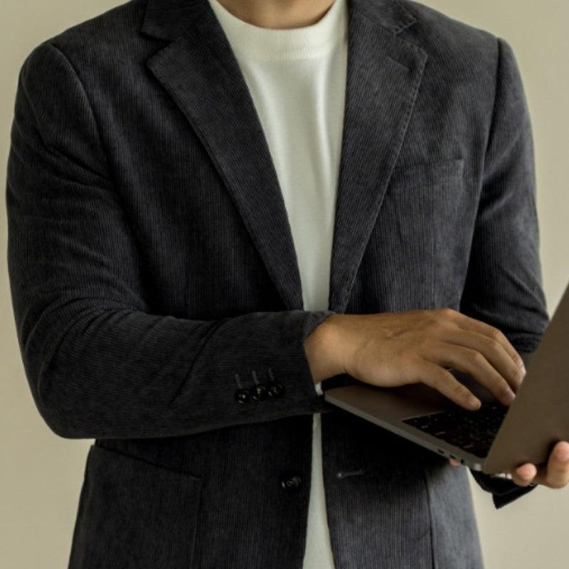 Black slim-fit blazer with notched lapels, long sleeves, and two-button cuffs