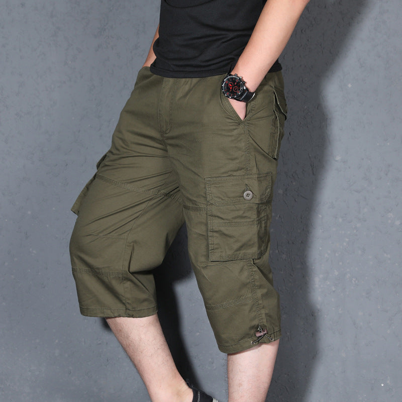 Men's olive cargo shorts, loose knee-length design with flap pockets and drawstring hem.