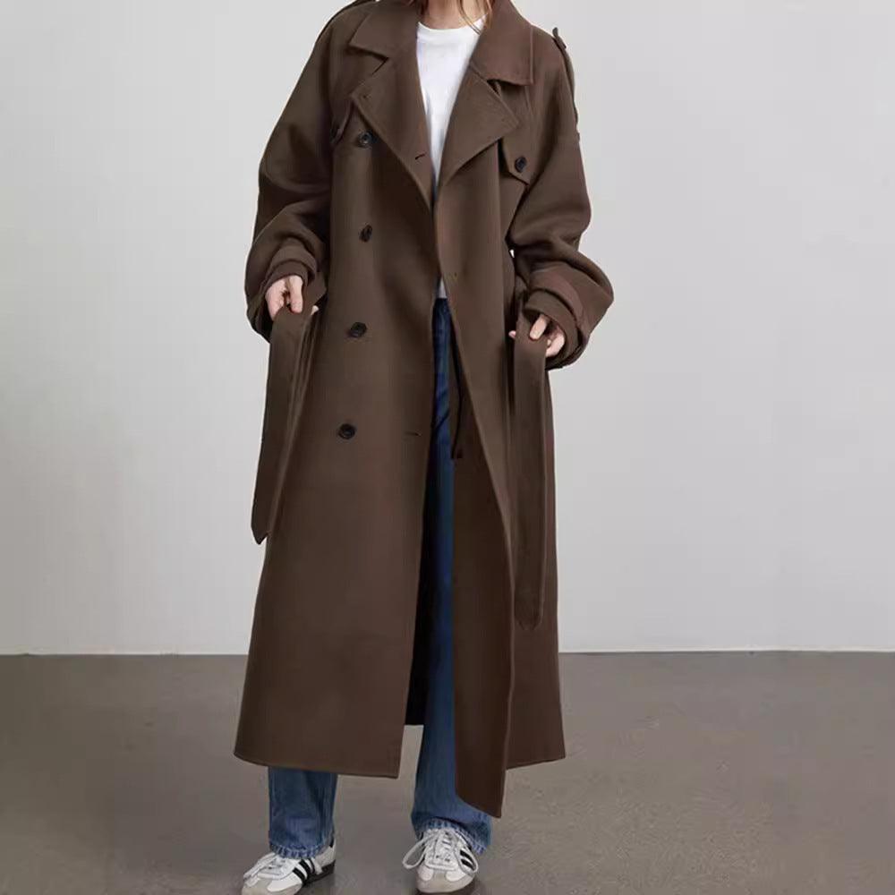 Brown long-cut coat with notched lapel, double-breasted buttons, and flap pockets.