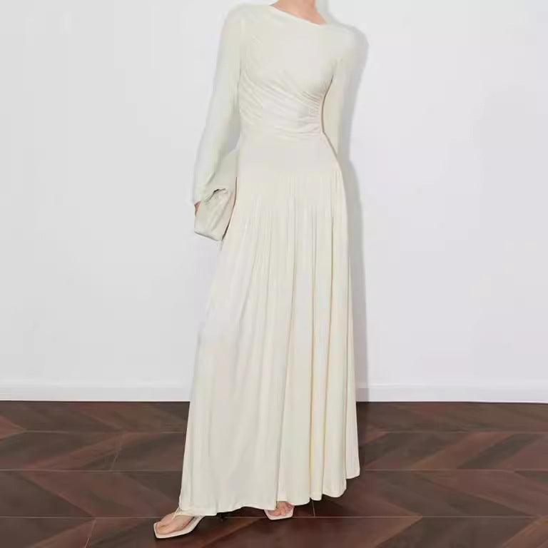 Beige long-sleeve maxi dress with ruched waist and pleated, flowing skirt