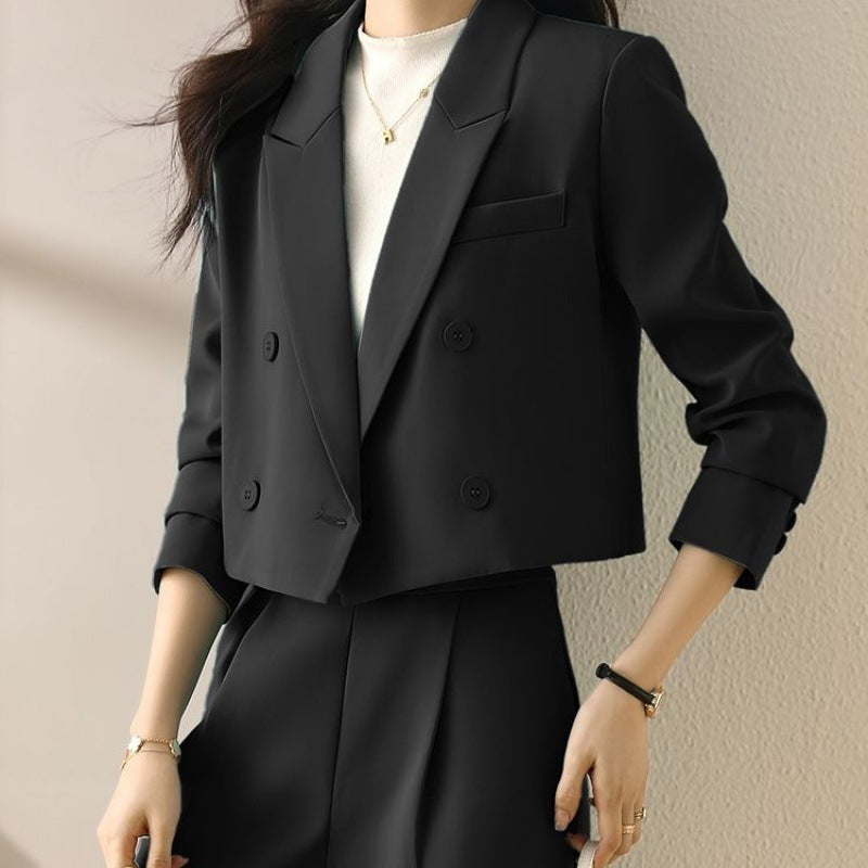 Black short suit blazer with notched lapels, button closure, and sleeve button details.