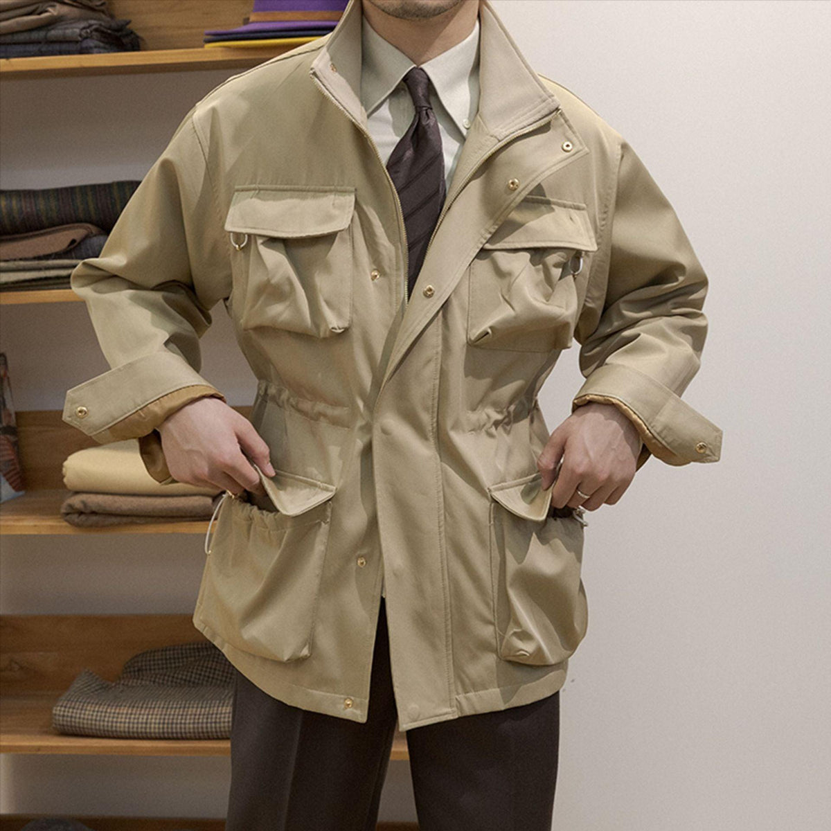 Khaki baggy coat with flap pockets, button front, and sleeve tab details