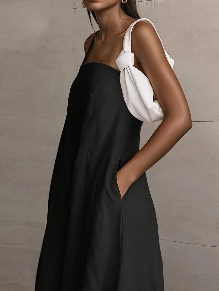 Black strapless midi dress with smooth drape and white knotted shoulder strap