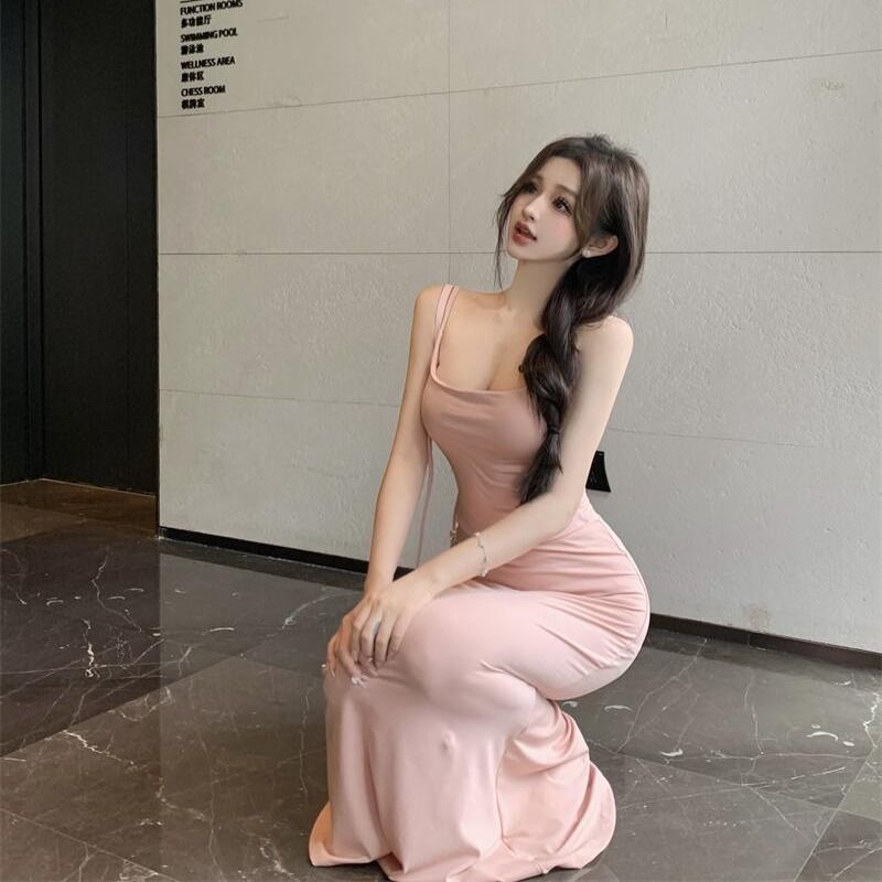 Pink sleeveless bodycon maxi dress with spaghetti straps and ruched waist.