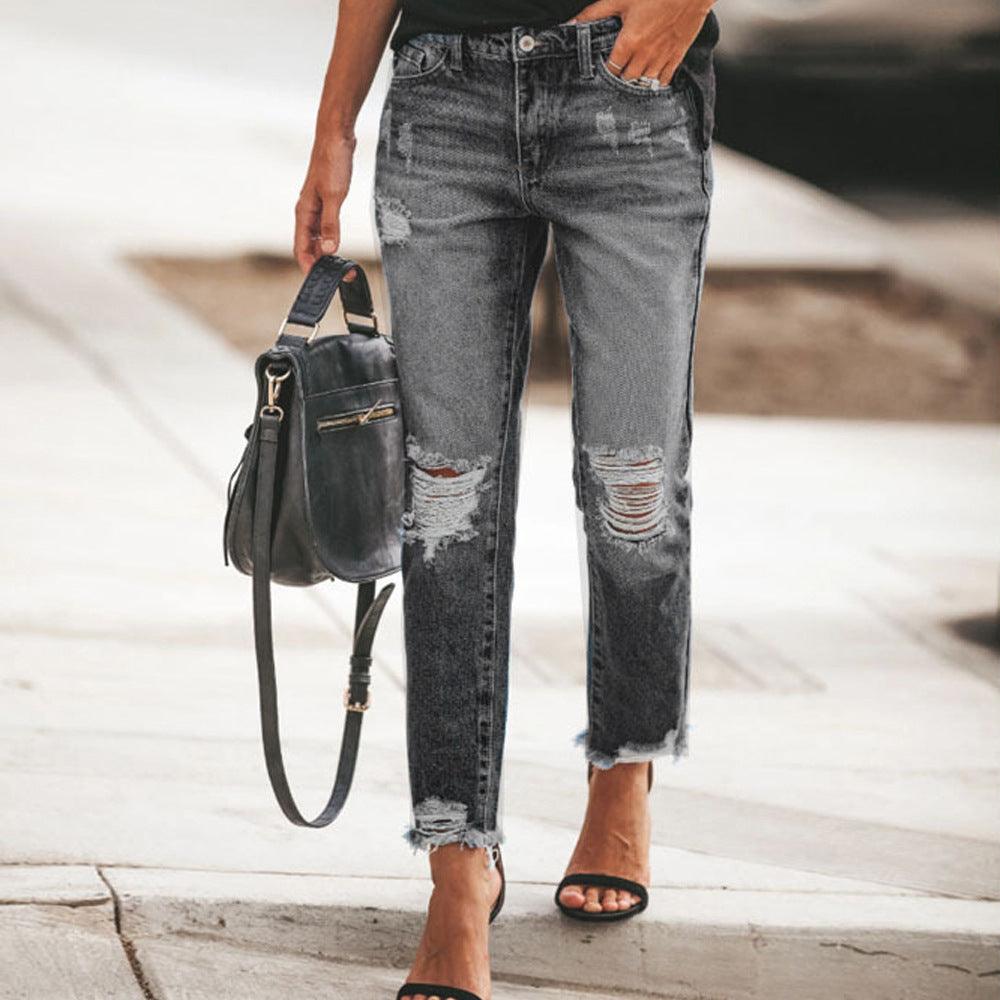 Women's dark gray ripped jeans with frayed knees and distressed side rips
