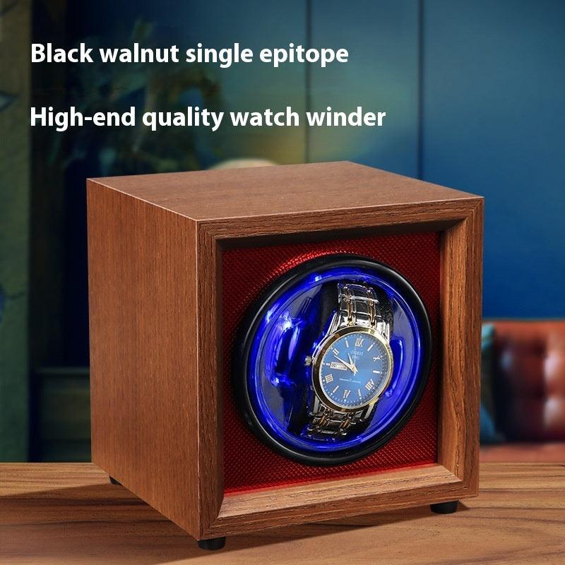 Wood watch winder with blue LED window, displaying an automatic wristwatch inside.