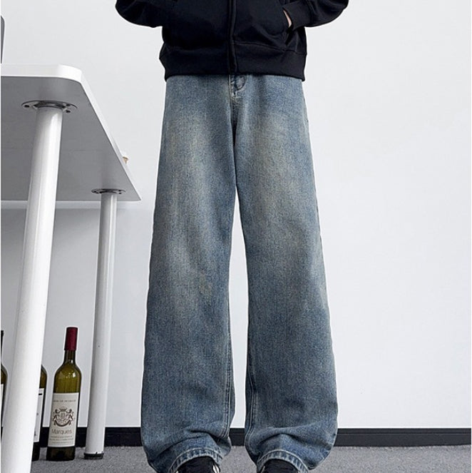 Men's light-wash distressed jeans with wide straight legs and worn lower hems