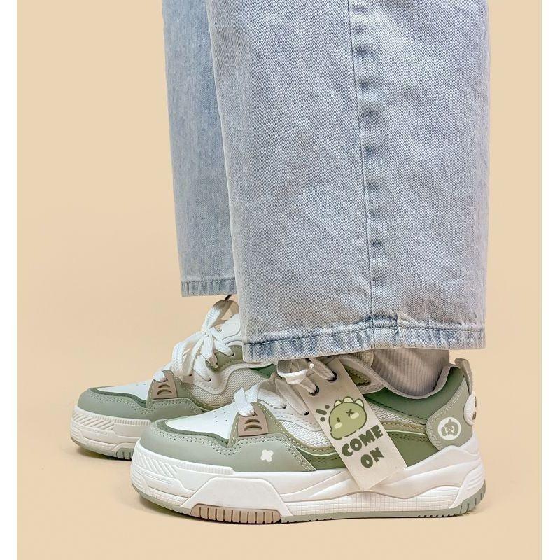 Green and white platform dad sneakers with white laces and graphic patch details