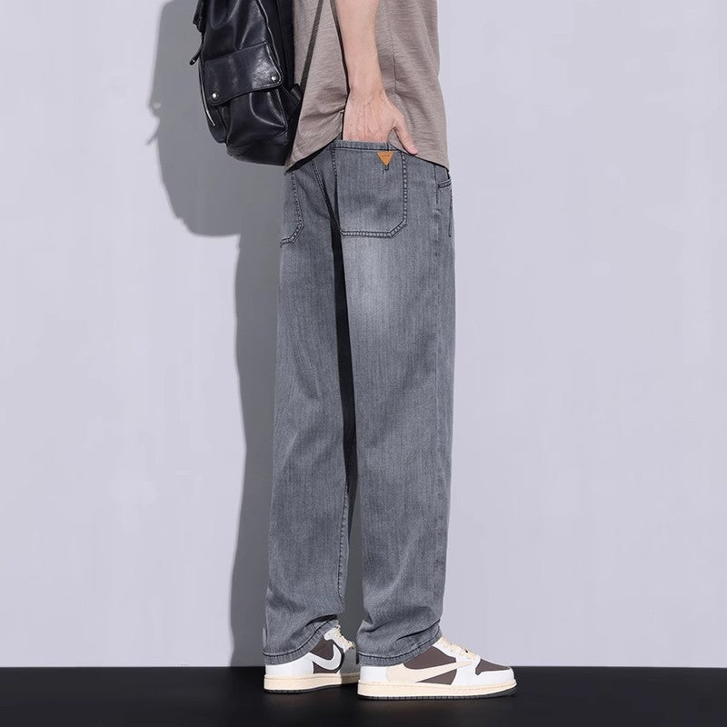Washed gray long pants with wide relaxed legs, back pocket, and orange tag.