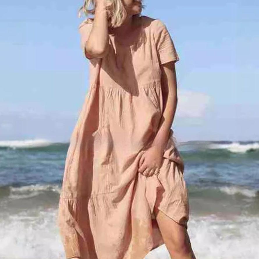 Tan loose round-neck dress with short sleeves and side pocket detail