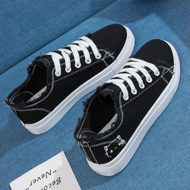 Women’s canvas sneakers in black with lace-up front, low-top rubber sole.