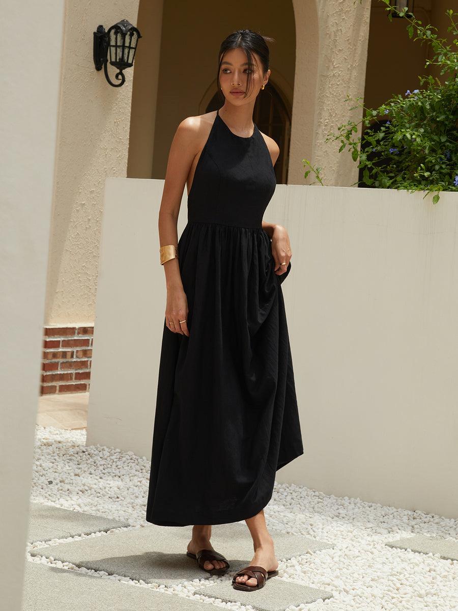 Black sleeveless maxi dress with gathered skirt and thin shoulder straps, full body