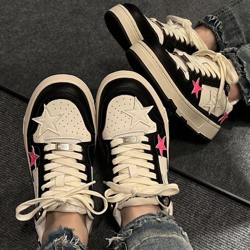 Beige lace-up sneakers with star overlays, pink star accents, and chunky sole