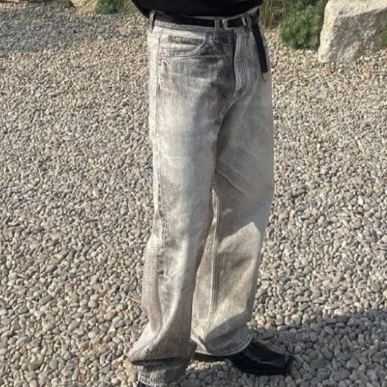 Gray wash jeans with whisker-style fade and distressed cat-whisker holes, relaxed fit