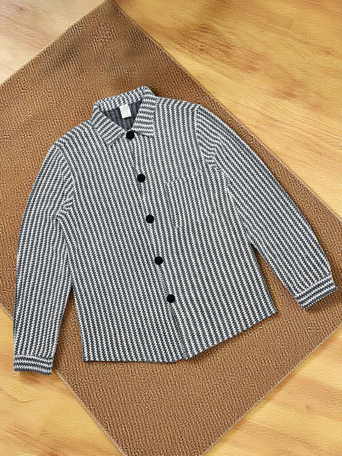 Striped button-up knit jacket folded, black-and-white textured fabric close-up