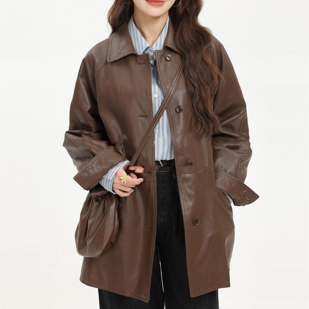 Brown leather coat with spread collar, snap buttons, and crossbody chest strap detail