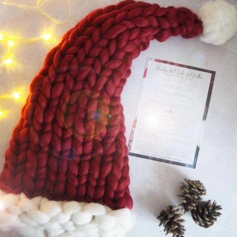 Deep red chunky knit Christmas hat with white brim and side pom pom