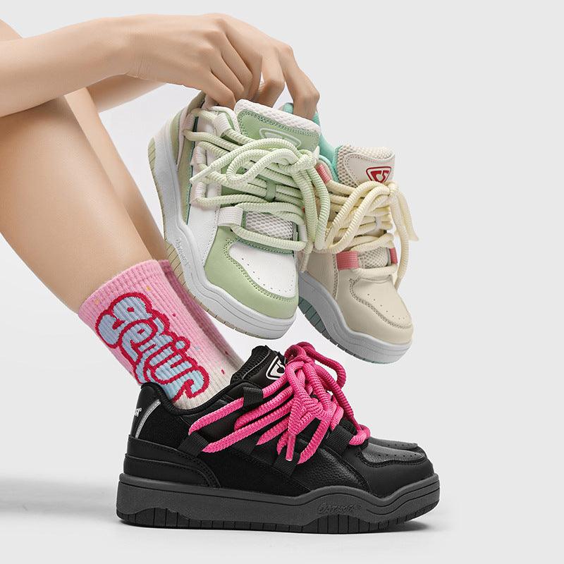 Chunky black retro sports shoes with bright pink laces and textured sole
