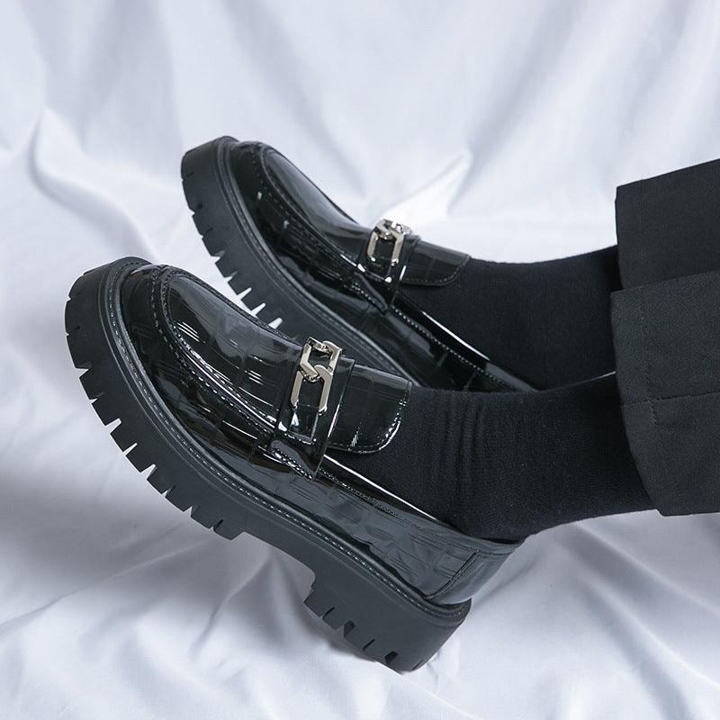 Black glossy leather loafers with double buckle straps and chunky tread sole, side worn