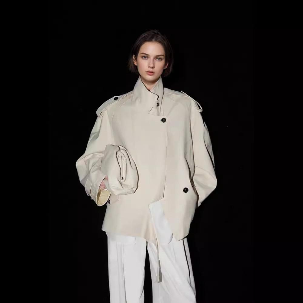 Off-white wide trench coat with button front, shoulder epaulets, and flap pockets