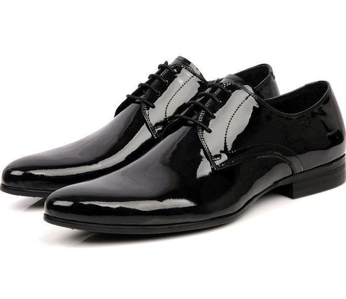 Black and white pointed-toe lace-up leather shoes, glossy patent-like finish, angled view