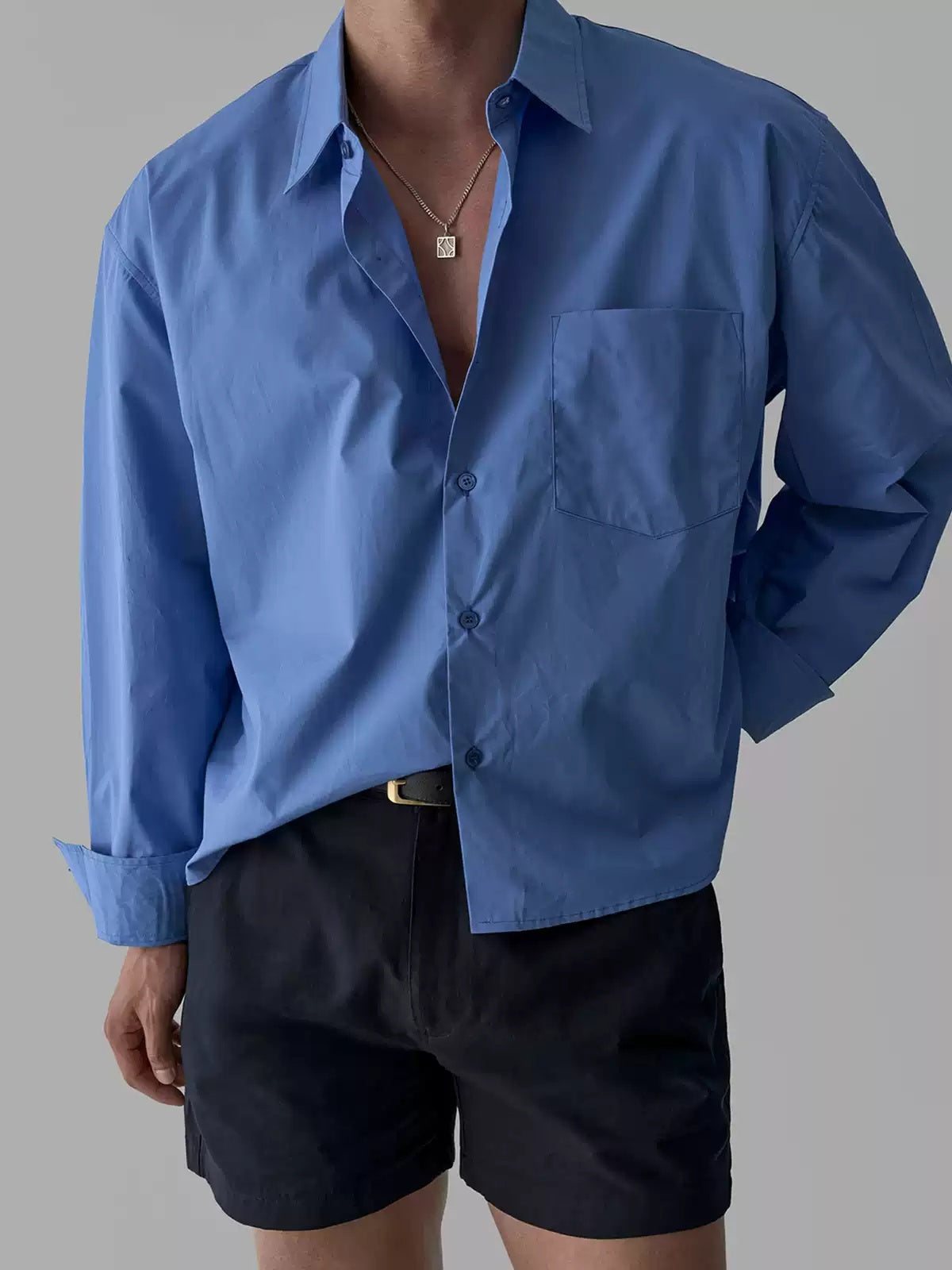 Men's blue long-sleeve button-up shirt with single chest pocket, close chest view