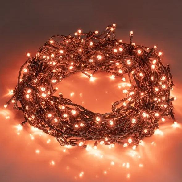 Orange LED fairy string lights with round bulbs on dark wire, glowing warm