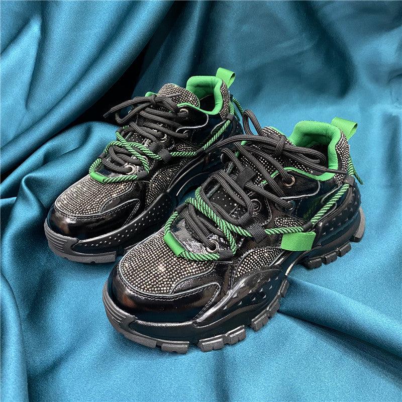 Black lace-up platform sneakers with green lace accents and chunky tread sole