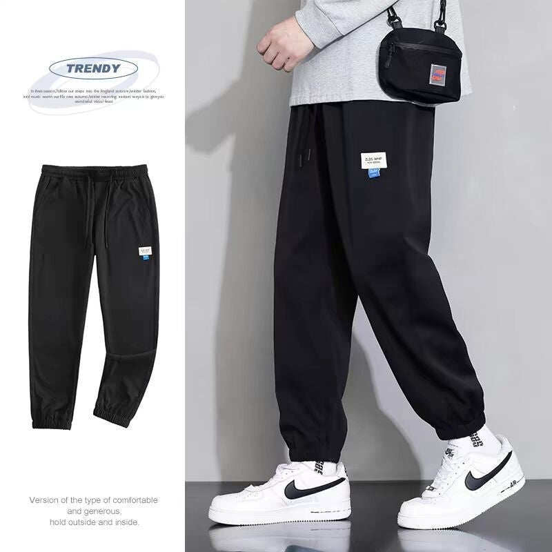 Black draping sports jogger pants with elastic ankle cuffs and drawstring waist