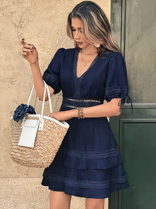 Women’s navy blue V-neck tiered mini dress with puff sleeves and eyelet trim