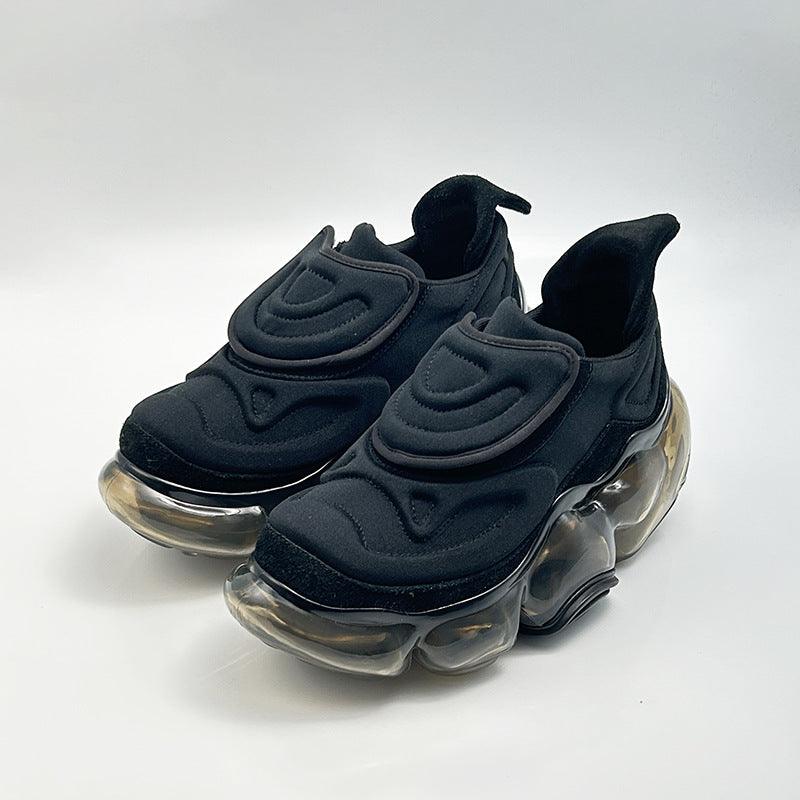 Black chunky sneakers with hook-and-loop straps and clear air-cushioned outsole