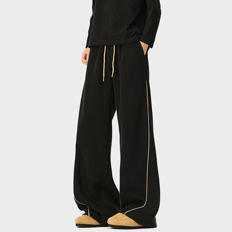 Black striped sports sweatpants with gold piping and drawstring cuffs
