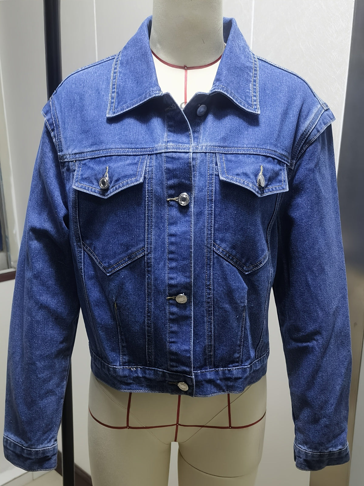 Blue washed denim jacket with button front and flap chest pockets, long sleeves.