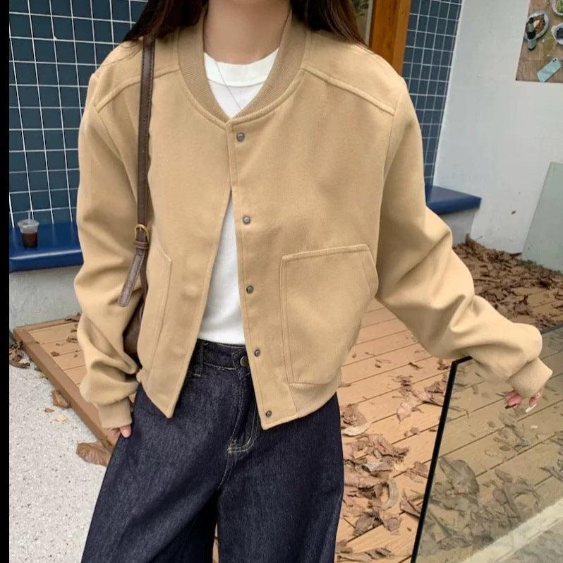 Short baseball jacket in light tan with snap button front, ribbed V-neck collar, chest pocket