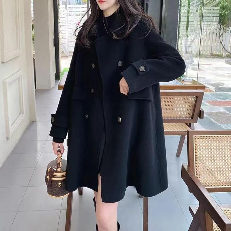 Black wool coat with double button rows, flap pockets, and structured long sleeves